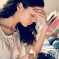 A woman with long brown hair sitting in front of her laptop, who had a miscarriage