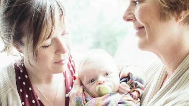 A younger and an older woman cuddling a baby