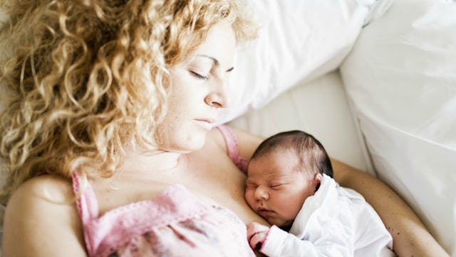 Mother in a bed with her newborn child after delivery