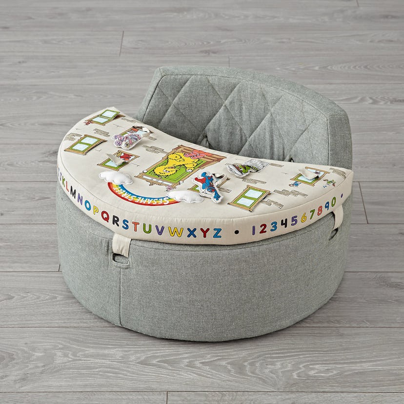 Grey activity chair for babies containing letters and numbers on the sides and other elements on bei...