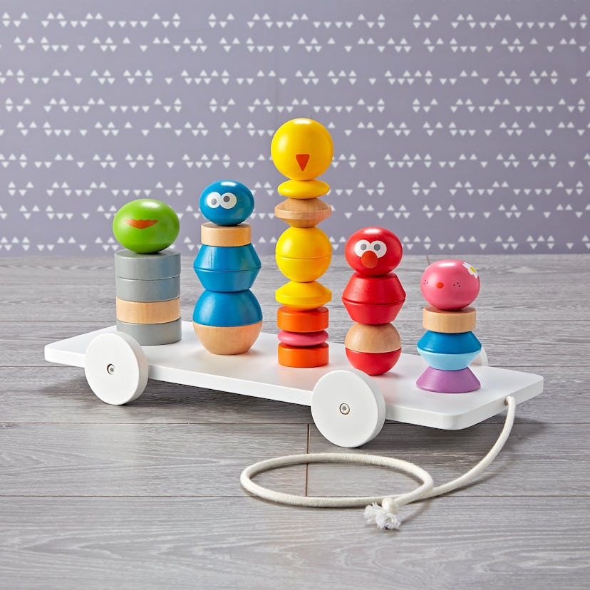 Wooden stacking toy featuring Oscar, Cookie, Big Bird, Elmo and Abby.