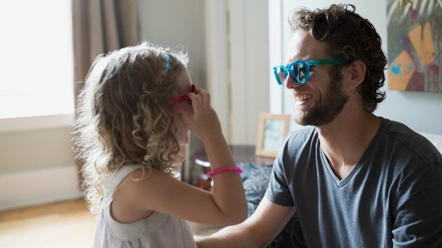 Dad having fun with his daughter, wearing different colored sunglasses.