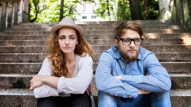 Moody couple sitting on outdoor stairs