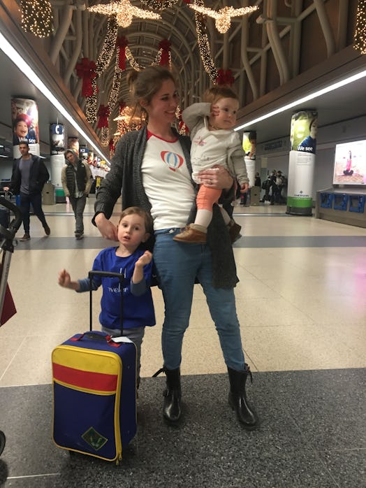 Mother with her two kids and a suitcase at the airport 