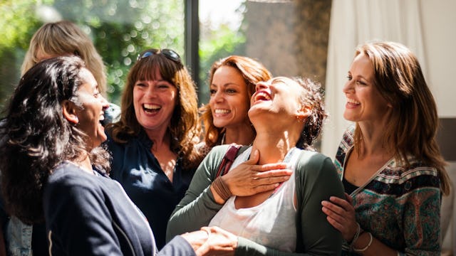 A group of women smiling and laughing during girls' weekend