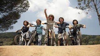 Five boys about to ride their bikes outside