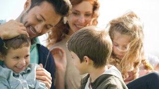 A blended family of 5 having fun together and smiling.