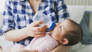 A mother holding a baby and bottle-feeding her instead of breastfeeding her