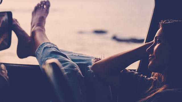 A girl and her feet relaxing through a car window who doesn't give a damn anymore about certain thin...
