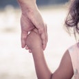 A kid holding her estranged mother's hand 
