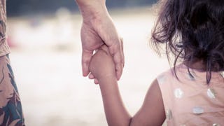 A kid holding her estranged mother's hand