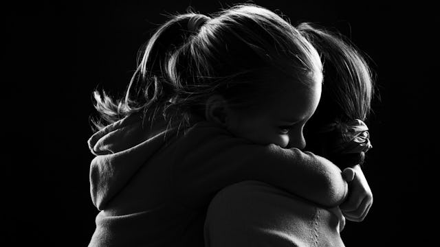 A young girl hugging her mother with diagnosed PTSD