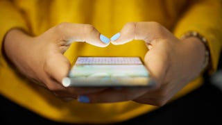 A close-up of a mom holding a smartphone and chatting in an online mom group