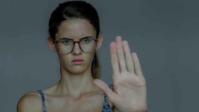 A young girl pointing her opened fist as a stop sign