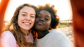 Two teenage girls posing and smiling for a selfie.