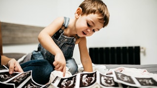 Little Boy Looking At the Ultrasound Pictures of a second child
