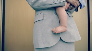 A working mom wearing a suit carrying her baby who does not have working mom guilt