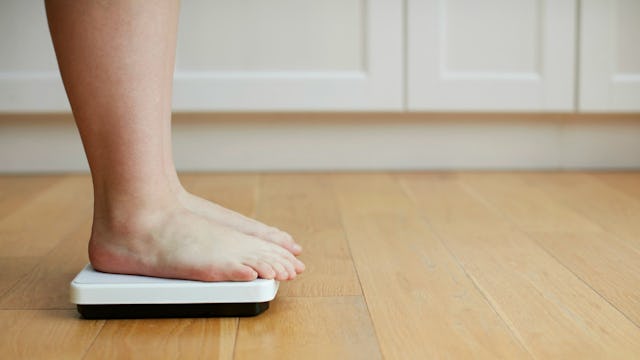 Woman weighting herself on a scale