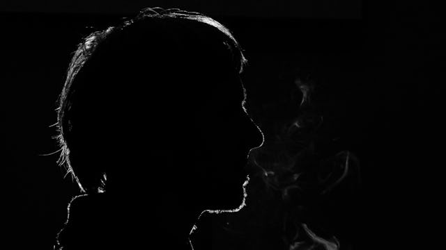 Black and white silhouette of a man smoking