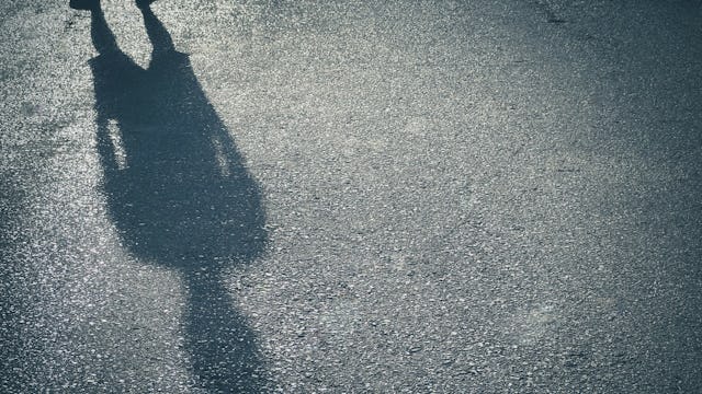 A man's shadow on the asphalt