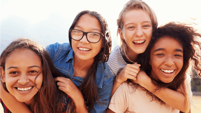 A group of childhood friends laughing and posing and smiling together