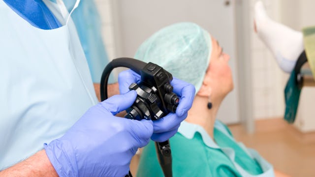 A doctor and a nurse preparing to perform a colonoscopy with the patient next to them
