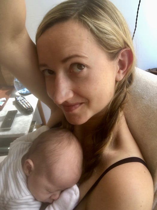 Mélanie Berliet taking a selfie with her baby sleeping on her chest