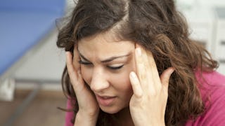 a woman touching her head, a woman with a headache