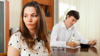Financially stressed couple sitting together at the table as it is taking a toll on their marriage