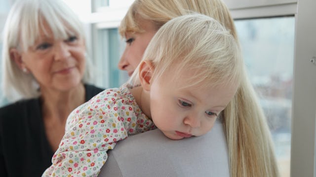 Mother holding her baby while speaking to her her mother-in-law