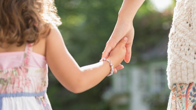 A mom holding her only daughter's hand while walking together