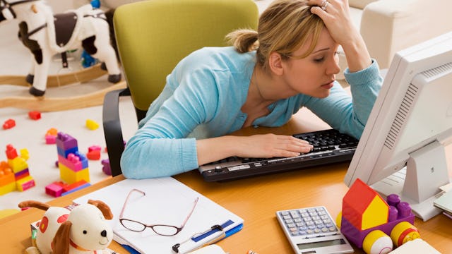 An exhausted woman leaning on her desk, feeling overwhelmed