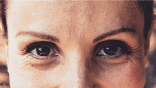 A close-up a a brunette woman's brown eyes 