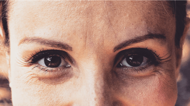 A close-up a a brunette woman's brown eyes