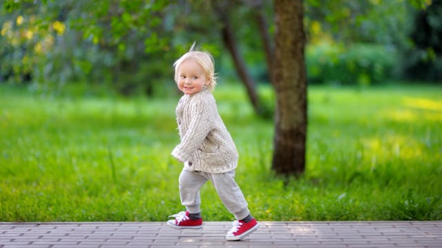 A happy toddler who is running in a park