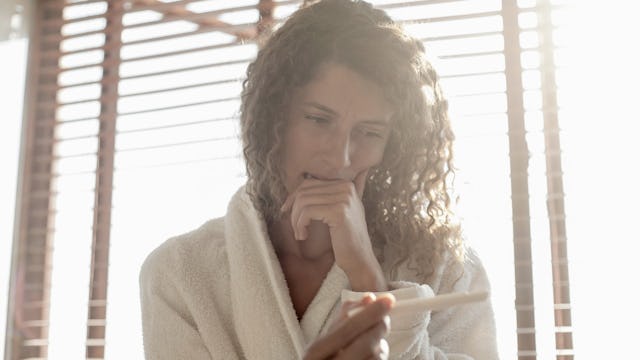 Concerned woman looking at a pregnancy test during the last month she will try to get pregnant