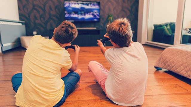 Two kids playing violent video games in their living room