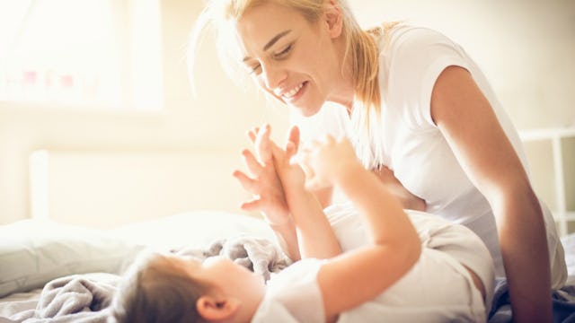 A working mom smiling and playing with her baby