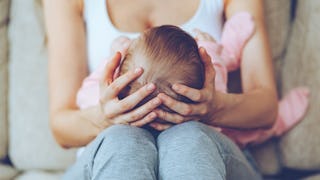 A mother holding her baby on her lap 