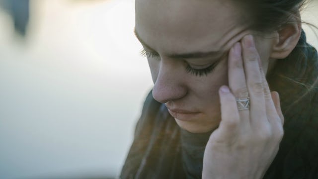A woman with chronic pain pressing her fingers on her forehead