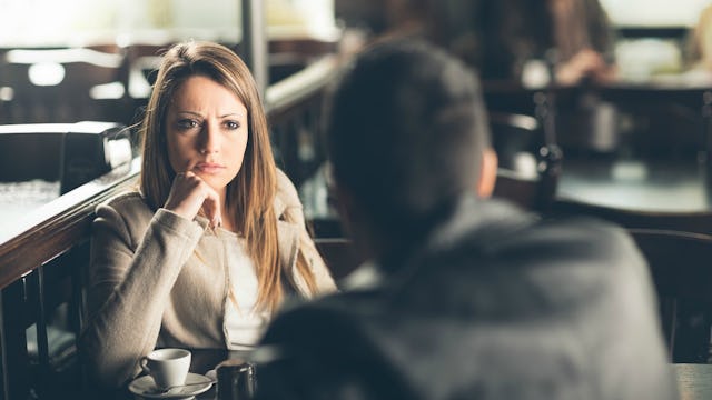 A girl sitting down and carefully listening to a guy in front of her