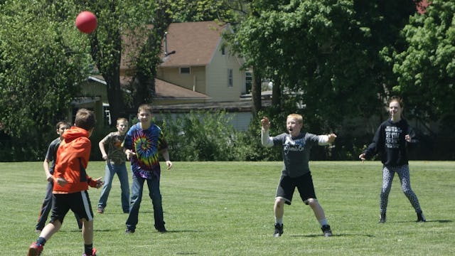 Boys from the neighborhood playing with a ball on a grass field