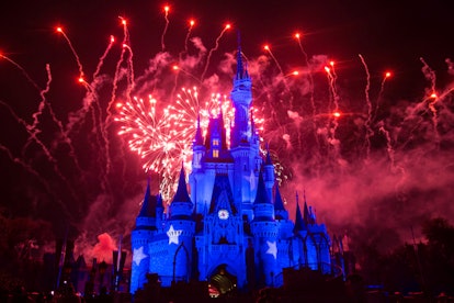 Red fireworks above a Disney castle in Disney Land at night 