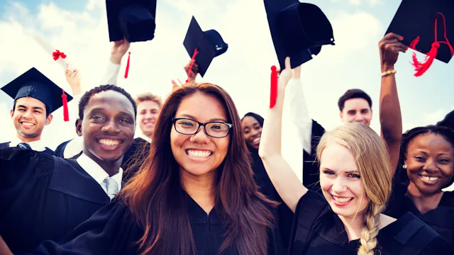 High school graduates holding their hats up in the air