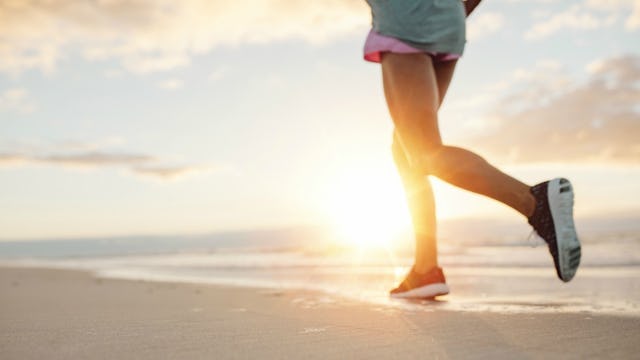 A woman running down a sandy beach in black sneakers whose kids don't always come first