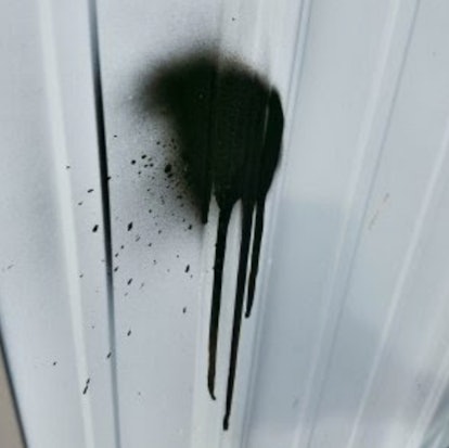 A black paint stain on a white door