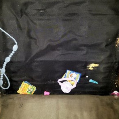 The inside of a foldable couch with food crumbles, jewelry and kid's stoys
