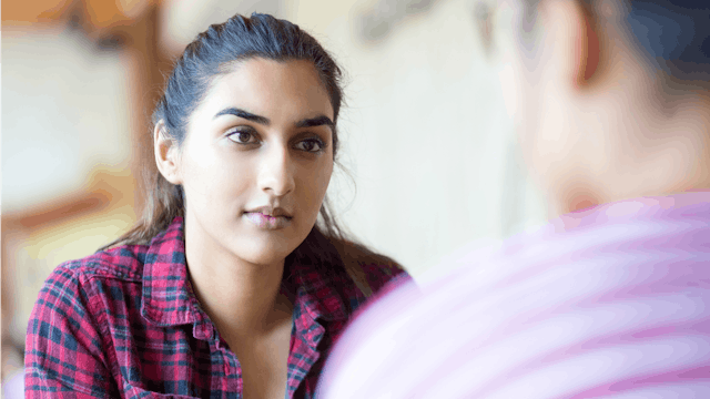 Young woman listening to a man talk while overthinking in her head