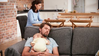 Father sleeping on a couch with his newborn 