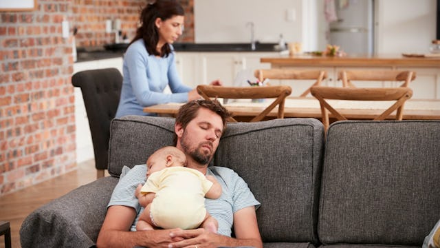 Father sleeping on a couch with his newborn